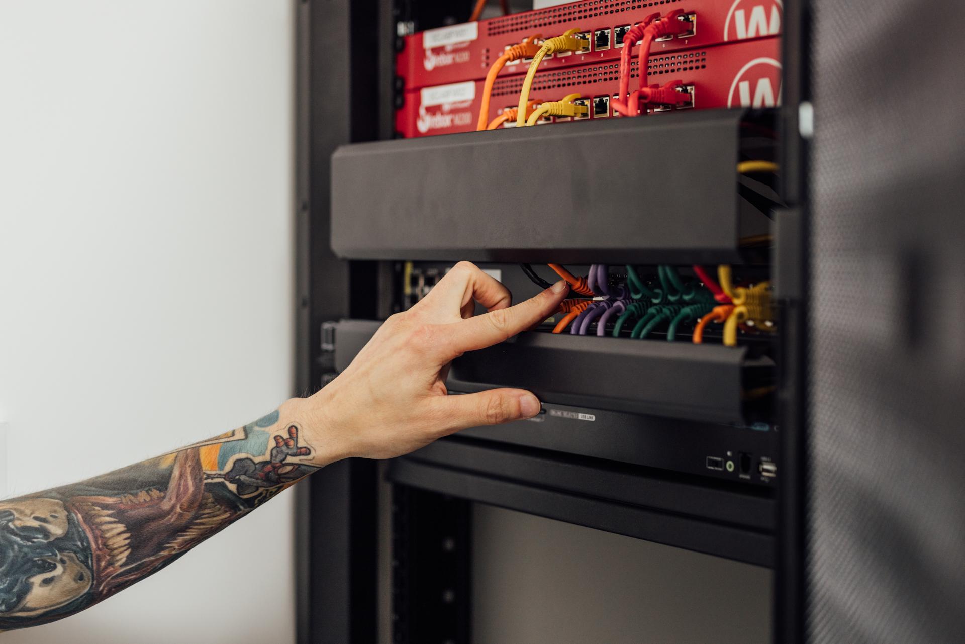 iemand wijst een switch aan in een serverrack