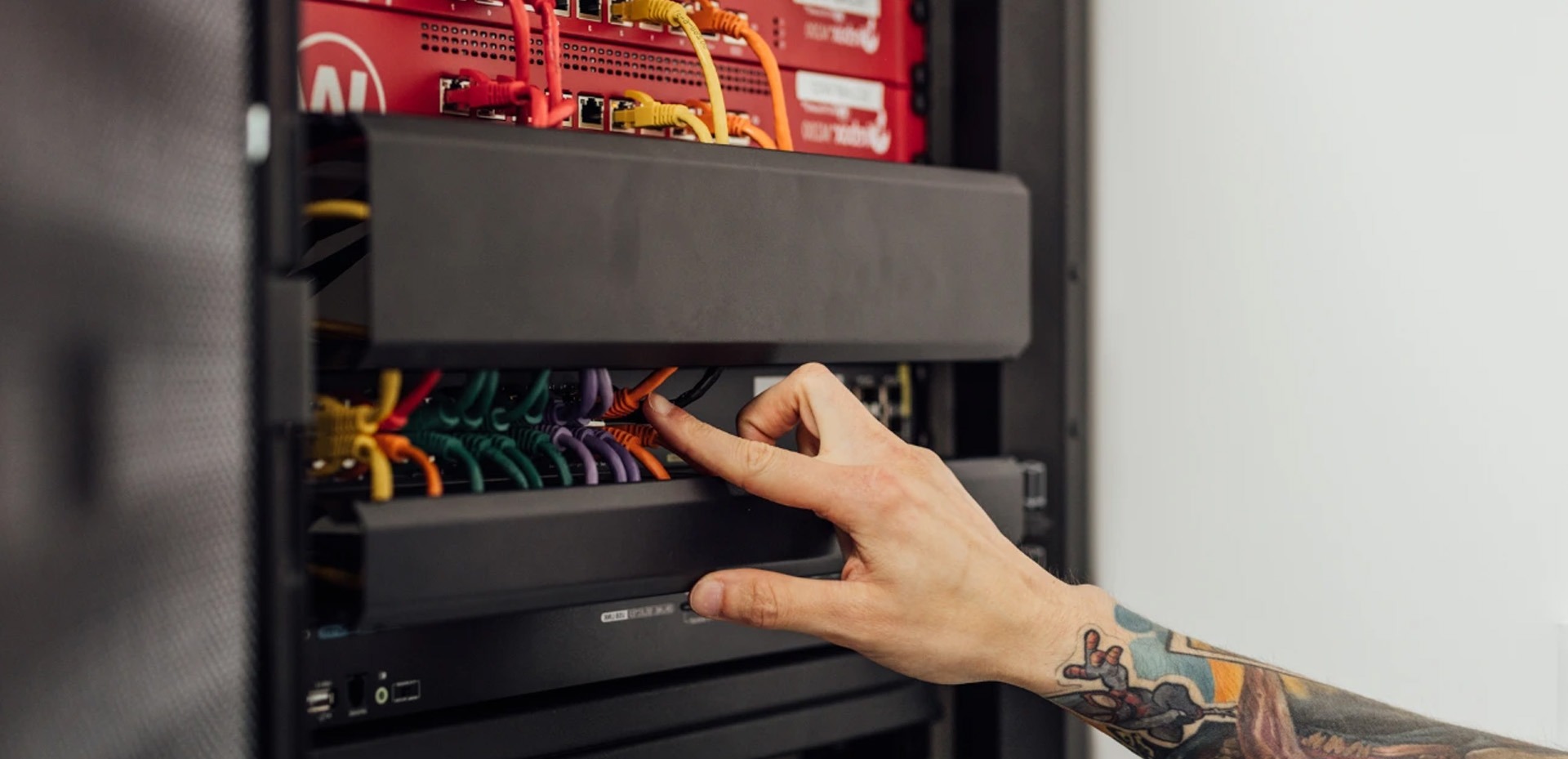 iemand die een switch aanduidt in de serverrack